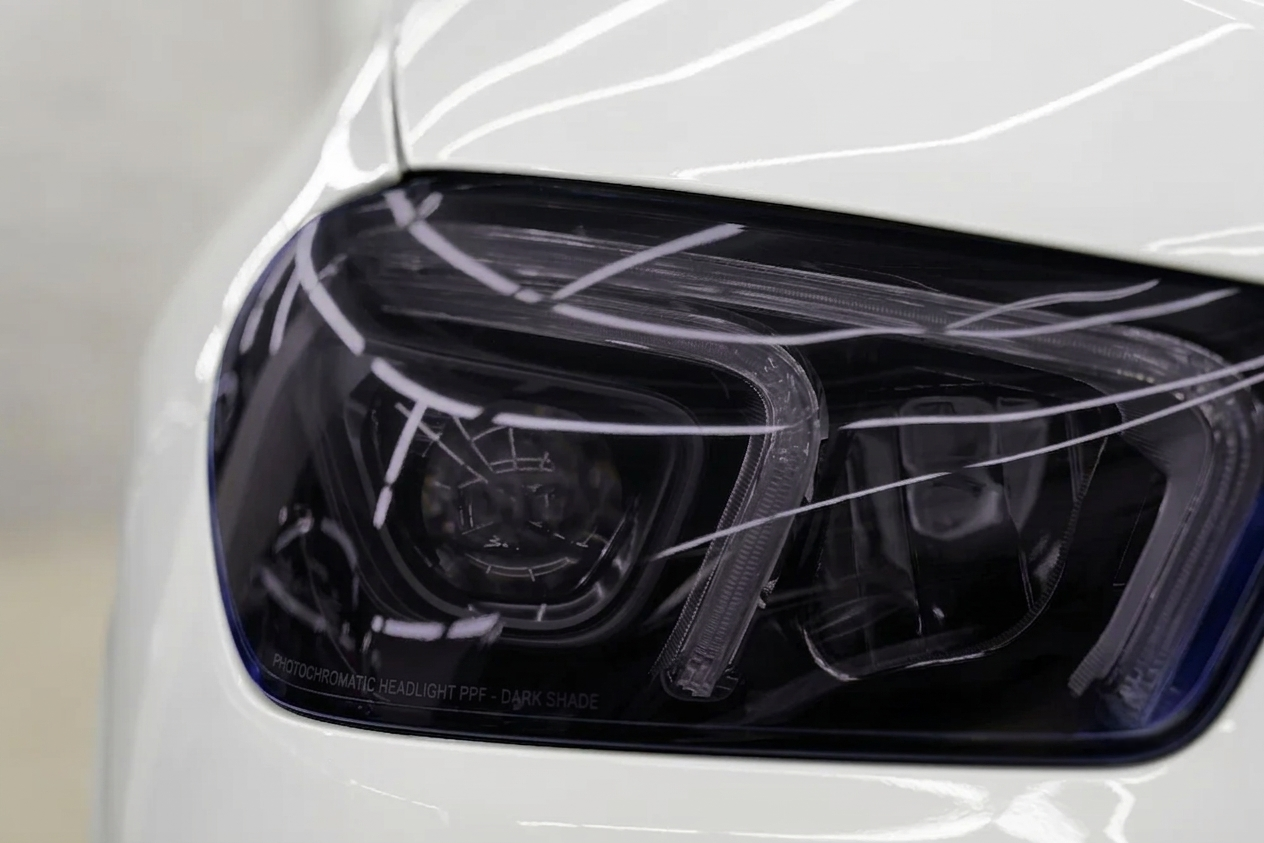 Automotive headlight protected with light-adaptive film